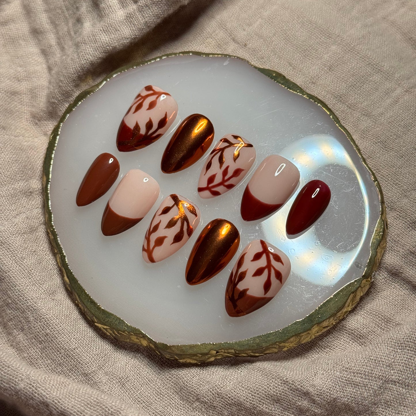 handmade brown and maroon press on nails with orange chrome leaf designs