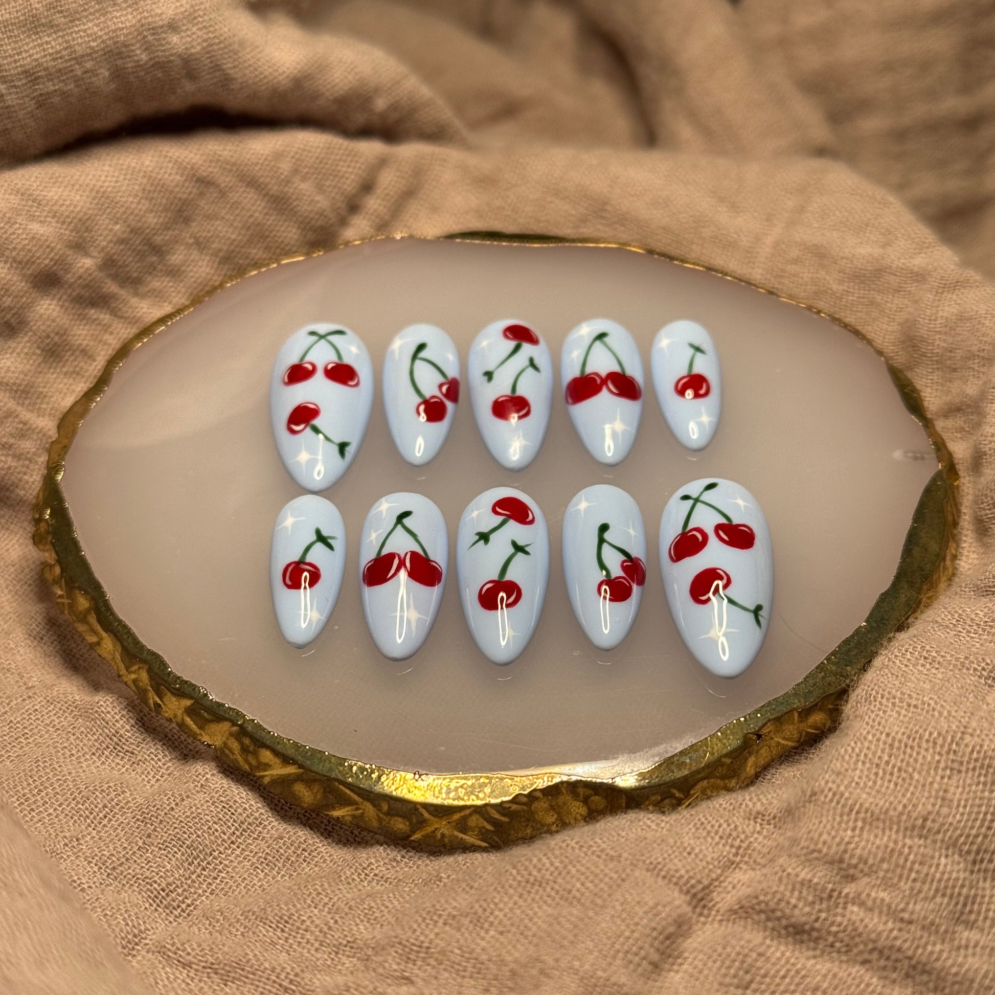 handmade light blue press on nails with deep red cherry designs and light star accent nails, reusable, custom handmade press on nails, easy at-home manicure