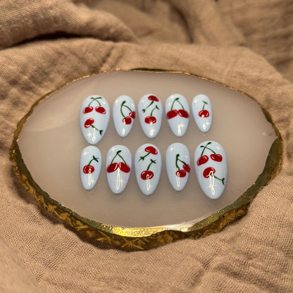 handmade light blue press on nails with deep red cherry designs and light star accent nails, reusable, custom handmade press on nails, easy at-home manicure