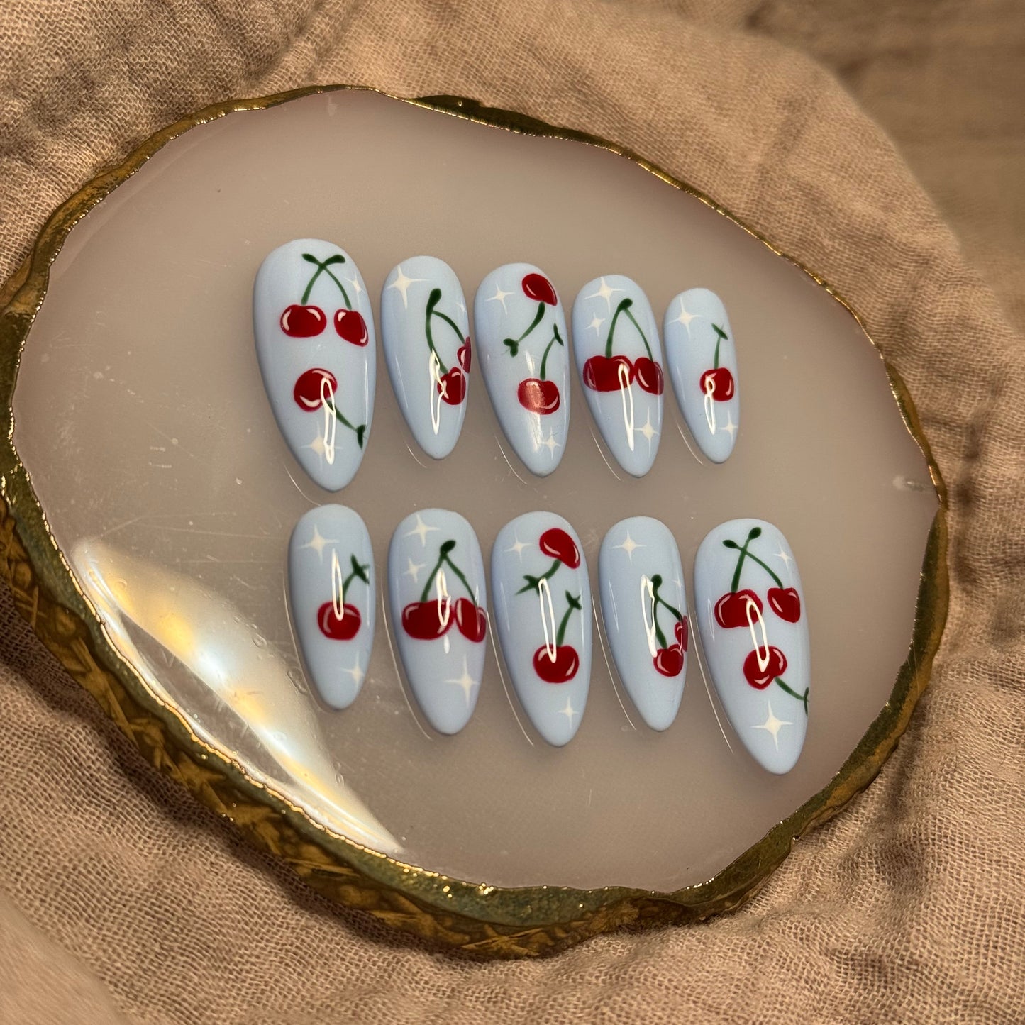 handmade light blue press on nails with deep red cherry designs and light star accent nails, reusable, custom handmade press on nails, easy at-home manicure