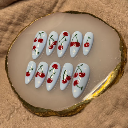 handmade light blue press on nails with deep red cherry designs and light star accent nails, reusable, custom handmade press on nails, easy at-home manicure